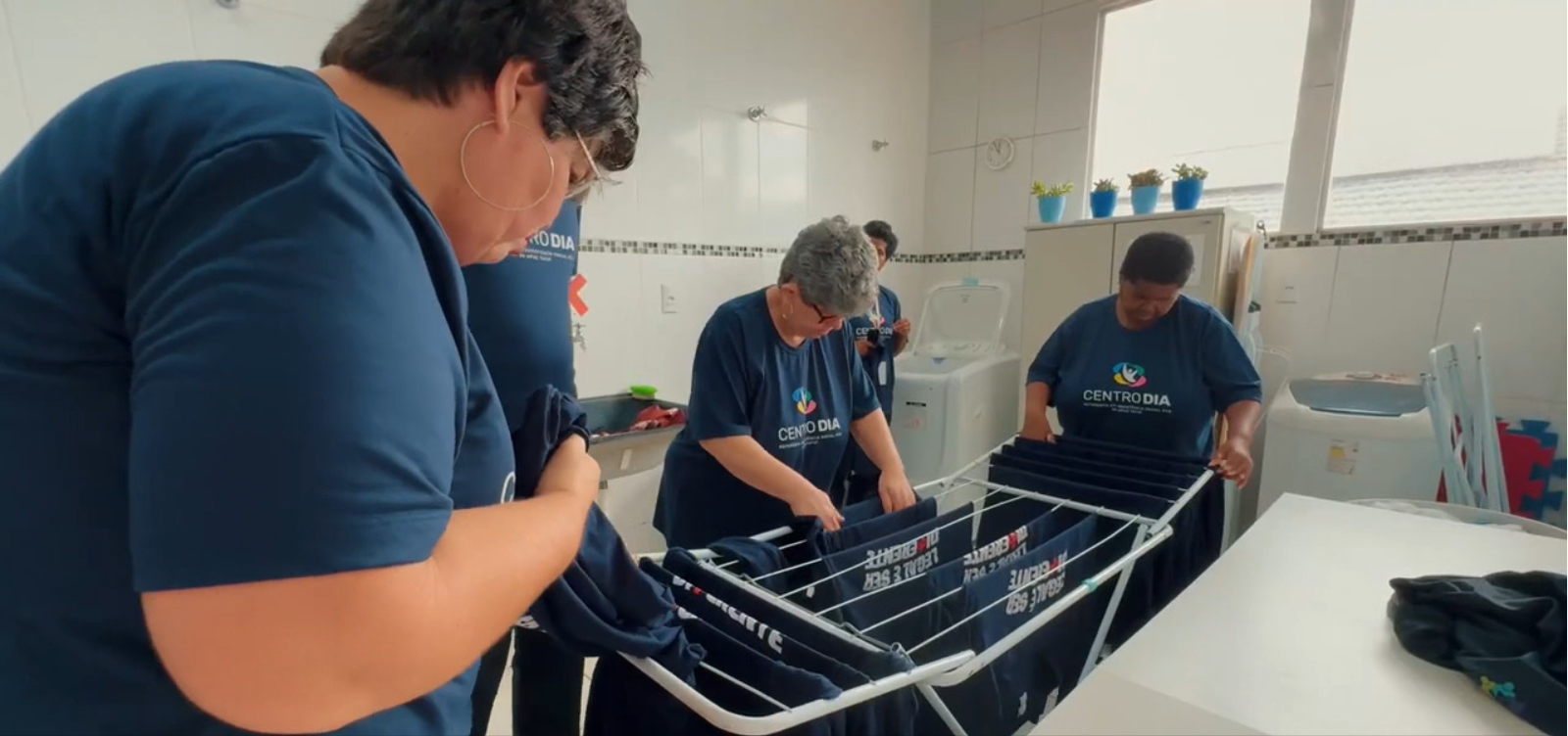 Equipe e usuários do Centro-Dia estendendo roupas